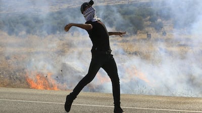 A protester hurls a stone at Israeli troops following the funeral of Palestinian Saad Dawabsheh in Duma on August 8. Abed Omar Qusini/Reuters