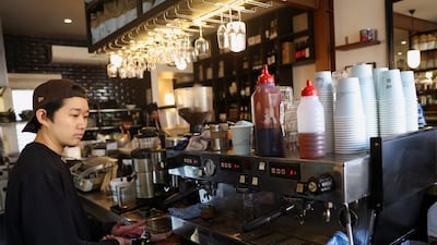 A worker makes coffee at Bar Zini, a cafe facing rising costs of raw materials, in Sydney. Reuters