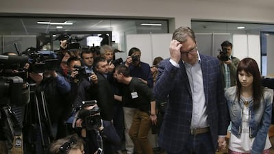 Current Serbian prime minister and presidential candidate Aleksandar Vucic waits at a polling station with his daughter Milica, in Belgrade, Serbia, Sunday, April 2, 2017. (AP Photo/Darko Vojinovic)