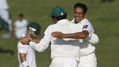 Zulifqar Babar, right, of Pakistan celebrates with a teammate during their first Test against South Africa at the Sheikh Zayed Cricket Stadium in Abu Dhabi on Monday. Karim Sahib / AFP