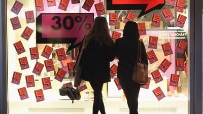 Two shoppers look at the display window of a shoe store advertising big sales in Berlin, Germany. Sean Gallup / Getty Images