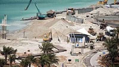 Workers from the National Marine Dredging Company are redeveloping and expanding the public beach on the Corniche.