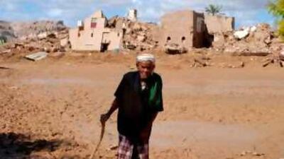 A Yemeni man walks in front of collapsed houses that belonged to his family in Mistah, to the east of the country.
