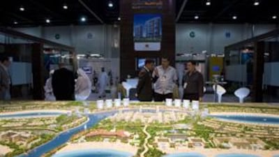People in front of a scale model of Mina Al Arab project at RAK Properties showroom during Cityscape Abu Dhabi.