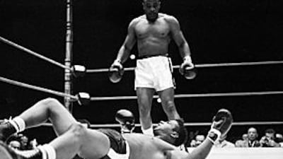 Sonny Liston stands over heavyweight champion Floyd Patterson after knocking him out in the first round of the title fight in 1962.