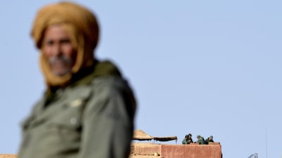 A file photo taken on February 3, 2017 a Sahrawi man standing in the Al-Mahbes area near Moroccan soldiers guarding the wall separating the Polisario controlled Western Sahara from Morocco. AFP