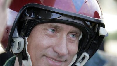 Putin poses for a picture after his arrival at Olenogorsk military airport, near Murmansk on August 16, 2005. AFP