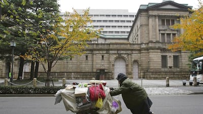 A man pushes a cart loaded with his belongings outside the Bank of Japan headquarters in Tokyo. Yuriko Nakao / Reuters