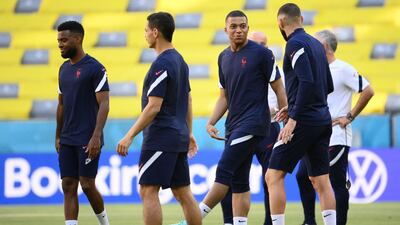 Kylian Mbappe talks with Karim Benzema during a training session at the Allianz Arena. AFP