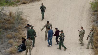US border patrol agents and National Guard soldiers detain migrants in La Joya, Texas. Reuters