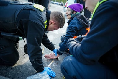 This activist's hand was firmly glued to the street near a Berlin landmark on Friday. AP