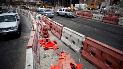 Construction workers work away to clean up remains of a crane that collapsed earlier that morning on Tuesday, July 12, 2011, during the morning rush hour in downtown Abu Dhabi. No one was hurt and only road blocks and the crane itself suffered damages. (Silvia Razgova/The National)