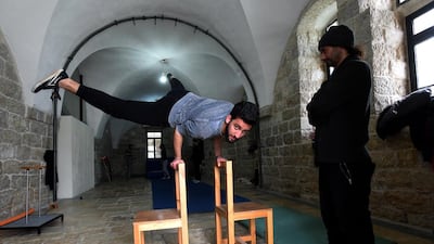 A Palestinian performer balances himself on two chairs. Other activities include juggling balls, clubs, diabolo and scarfs; balancing on the Chinese pole or a tight wire; and pedalling on a unicycle.