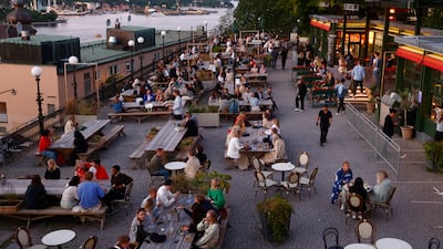 People sit outdoors at a restaurant in Stockholm, Sweden. On July 1, Sweden eased Covid-19 restrictions, including allowing diners to stay longer at eateries.