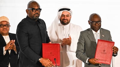 Qatar's chief negotiator Mohammed Al Khulaifi, centre, observes as Sumbu Sita Mambu, left, a high representative of the Democratic Republic of Congo, shakes hands with M23 executive secretary Benjamin Mbonimpa at the Sheraton Hotel in Doha. AFP