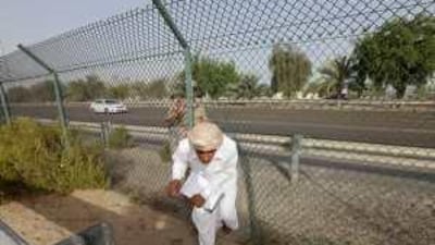 After running across the E11 highway linking Abu Dhabi and Dubai, students slip through a fence to go to school in Shahama.