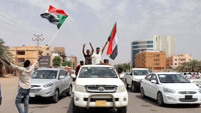 Protestors celebrate and carry the national flag on the streets of Khartoum Friday. EPA