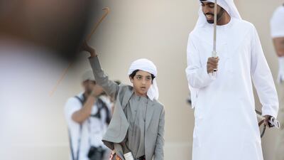 Sheikh Khalifa bin Theyab Al Nahyan, left, takes part in a traditional dance at the parade. Mohamed Al Hammadi / Presidential Court