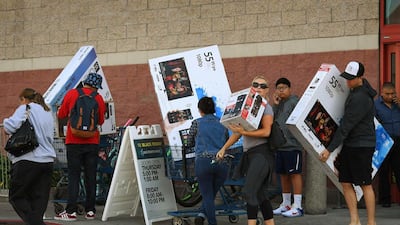 Shoppers with their arms full walk to their cars during the Black Friday sales at a Best Buy store in Culver City, California. AFP