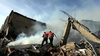 Palestinian firefighters try to extinguish a fire in a destroyed Hamas Ministry of Interior building after an Israeli air strike in Gaza City on Friday.
