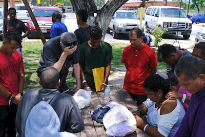 Father Kevin Collins leads a prayer after a Range Rover struck a group of migrants. AP