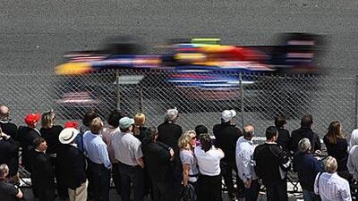 The crowds watch Mark Webber tear round the track on his way to pole position in Monte Carlo yesterday.