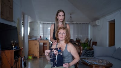 Evgenia Kozlov with a portrait of her son, Andrey, 27, and his girlfriend, Jenifer Master. Mr Kozlov, a Russian citizen, was abducted by Hamas militants. AP