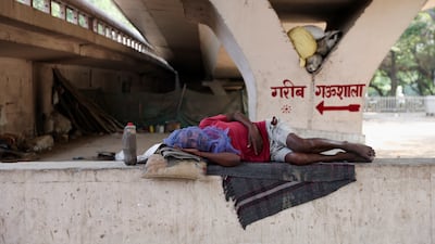 A man sleeps under a bridge in a bid to escape the searing heat in New Delhi. Reuters