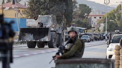 An Israeli security forces bulldozer arrives at a military roadblock after reports of Saturday's attack in Huwara in the occupied West Bank. AFP
