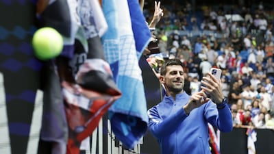 Novak Djokovic takes a selfie with a spectator after winning his match against Adrian Mannarino. EPA