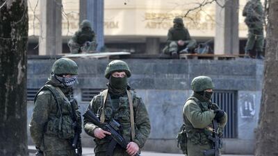 Unidentified armed men patrol in front of the Crimean Parliament in Simferopol on March 01. Pro-Russian forces tightened their grip on Crimea on Saturday as the Kremlin vowed to help restore calm on the restive Ukrainian Peninsula and Washington warned of "costs" to Moscow should it order in troops to deploy. Genya Savilov/AFP Photo