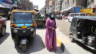 An Egyptian woman wearing a face mask walks at Bolaq district in Giza, Egypt. EPA