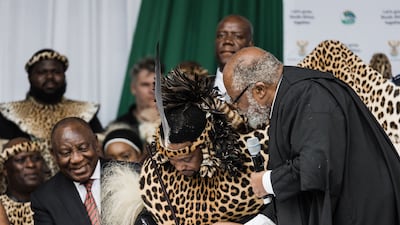 King Misuzulu Zulu, centre, flanked by South Africa's President Cyril Ramaphosa, left, signs final legal papers from acting KwaZulu-Natal Judge President Isaac Madondo during the coronation at the Moses Mabhida Stadium in Durban. AFP