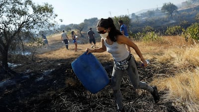 In western Madrid, two wildfires merged into a massive blaze on July 24, with residents helping to water the soil in the industrial area of San Martin de Valdeiglesias. AFP
