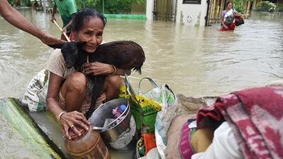 A woman clings on to her goat while sitting on a raft in Koliabor. Biju Boro / AFP Photo