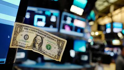A dollar bill is taped to a trader's computer screen at the New York Stock Exchange. Speculators are bearish as the currency's decline continues. Mark Lennihan / AP