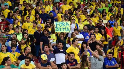 A supporter of Brazil displays a poster against Brazilian President Dilma Rousseff during the Russia 2018 Fifa World Cup South American Qualifiers’ football match between Brazil and Uruguay, in Recife, northeastern Brazil, on March 25, 2016. AFP PHOTO / CHRISTOPHE SIMON