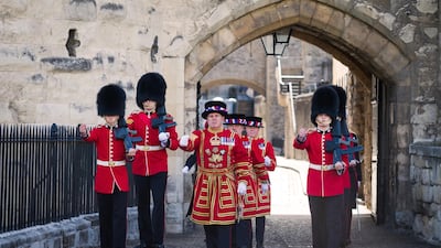 Yeoman Warders and Guardsmen march through the Byward Tower gates during a ceremonial event to mark the reopening to the public of the Tower of London. Getty Images