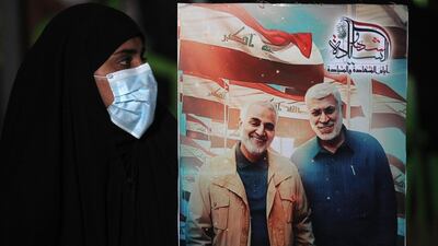 An Iraqi woman carries a portrait of Qassem Suleimani and Abu Mahdi Al Muhandis. AFP