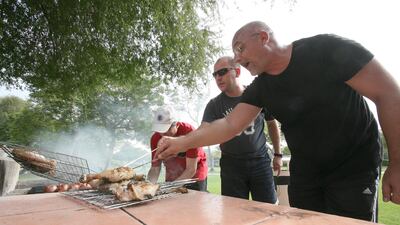 (L-R) Motaz Hadaya, Osama Adani and Nawar Adani from Syria cook on a barbecue at Safa Park on the first day of the Eid Al Adha holidays. Mike Young / The National