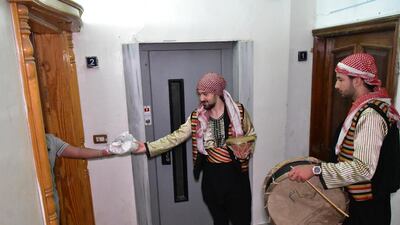 A Syrian man gives food to the Mosaharati who calls on Muslims to wake up to eat Suhoor before sunrise in Damascus, Syria. Syria has alleviated the curfew imposed on the country to prevent the spread of the coronavirus and reopened religious places for the first time during Ramadan. EPA