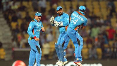 Afghanistan cricketers Mohammed Shahzad (C) and Gulabdin Naib (R) celebrate after winning their T20 World Cup cricket match against Zimbabwe at the VCA stadium in Nagpur on March 12, 2016. / AFP / Prashant Bhoot