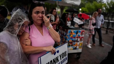 People listen in Lafayette Square to US President Joe Biden addressing the nation from the Oval Office about his decision to drop his Democratic presidential reelection bid. AP