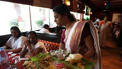 Ani Jacob serves a traditional meal set on banana leaves as part of the New Year menu at Nalukettu restaurant in the Dubai Grand Hotel.