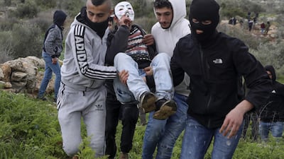 Palestinian protesters carry away a comrade amid clashes with Israeli forces in the northern West Bank city of Tulkarem following the funeral of 19-year-old Badr Nafla in the same city. AFP