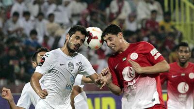 Al Ahli's Majed Hassan, left, battles Abdelaziz Barrada of Al Jazira for a header during Thursday night's action in Dubai. Jeffrey E Biteng / The National