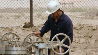 A worker controls a valve on a pipeline at the Zubair Moshrif oil field.