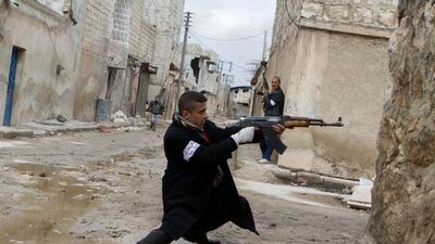 A Syrian rebel aims his weapon during clashes with government forces in Aleppo. Stephen Boitano / AFP