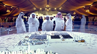 Officials and delegates from Dewa (Dubai Electricity and Water Authority) look at a model that represents the entire proposed Mohammed bin Rashid Al Maktoum Solar Park. Antonie Robertson / The National