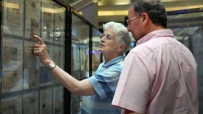 Jenny Banfield, a collector from New Zealand, shows off her prized collection to Freddy Khalastchy, a philatelist from London, at the Arabian Stamp Exhibition in Sharjah yesterday